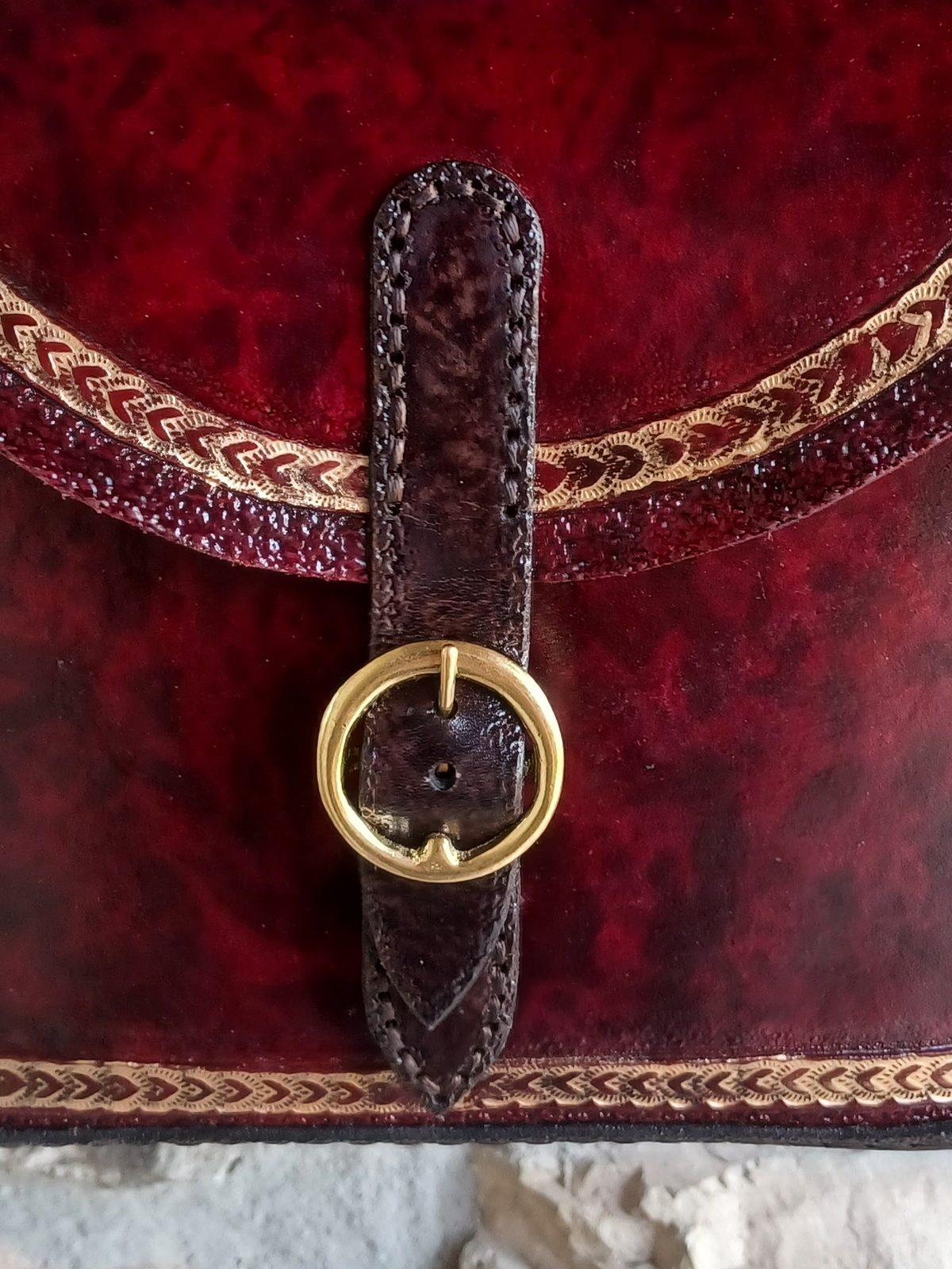 Close detail of gold-leaf tooling on hand-dyed leather